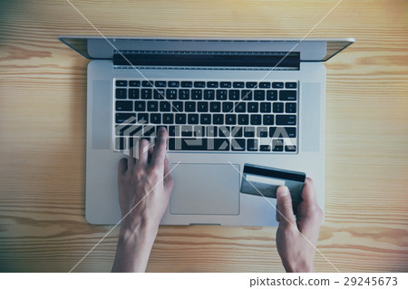 Hands holding credit card and using laptop Hands holding credit card and using laptop 29245673