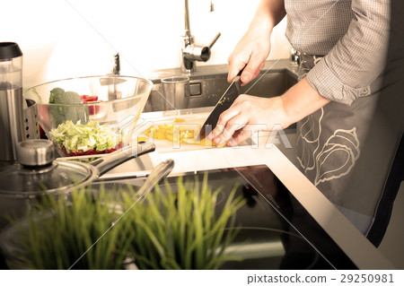 Man chopping paprika on cutting board with knife Man chopping paprika on cutting board with knife 29250981