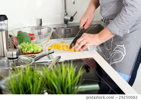 Man chopping paprika on cutting board with knife Man chopping paprika on cutting board with knife 29250982