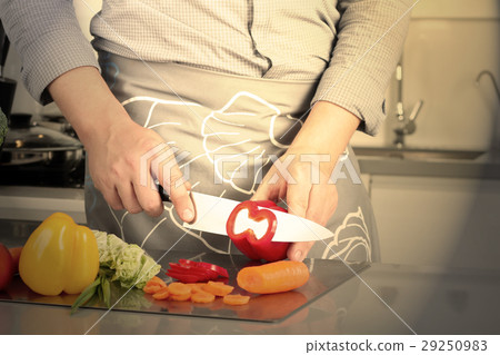 Man chopping paprika on cutting board with knife  29250983
