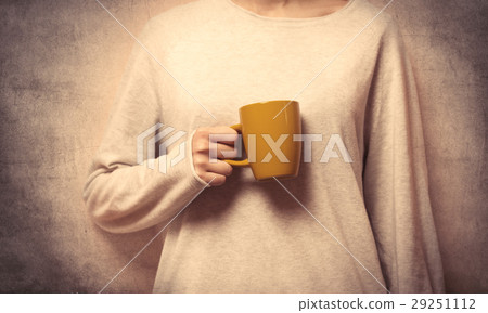 hand holding a yellow cup 29251112