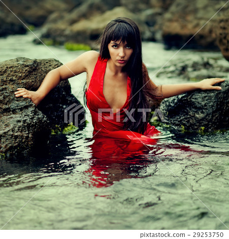 brunette lady in red dress in the water 29253750