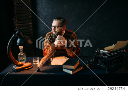 Bearded writer in glasses sitting at the table Bearded writer in glasses sitting at the table 29254754
