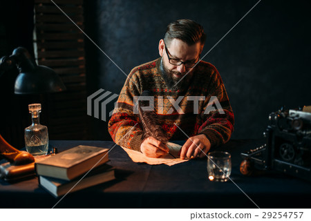 Bearded writer in glasses writes with a feather Bearded writer in glasses writes with a feather 29254757