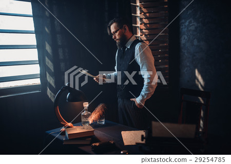 Bearded man in glasses reads handwritten text 29254785