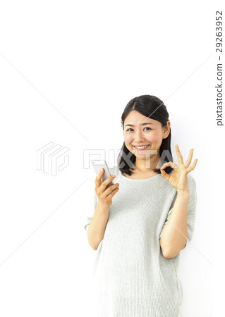 A woman with an OK sign with a smile and a smile. 29263952