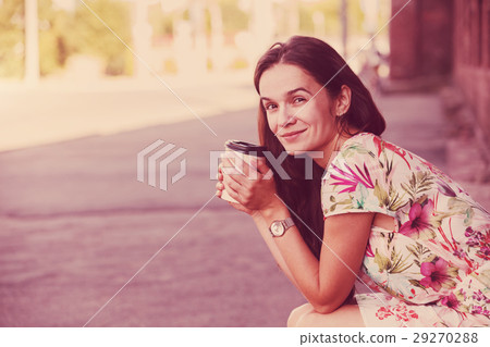 pretty girl sitting in street with morning coffee 29270288