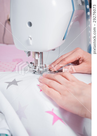 Woman's hands with dress at sewing machine 29276073