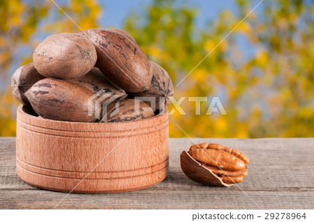 pecan nuts in a wooden bowl on the old board with pecan nuts in a wooden bowl on the old board with 29278964