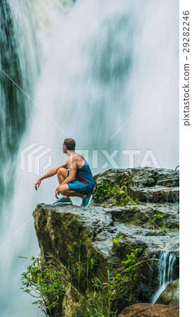 Man sitting in Front of Tegenungan Waterfall near Man sitting in Front of Tegenungan Waterfall near 29282246