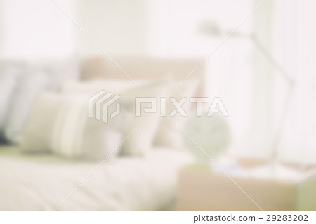 blurred bedroom with reading lamp and alarm clock 29283202