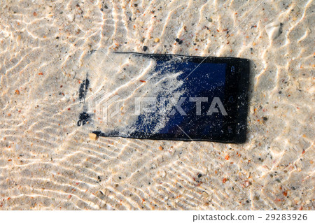 Mobile phones on the sand under the sea water. Mobile phones on the sand under the sea water. 29283926