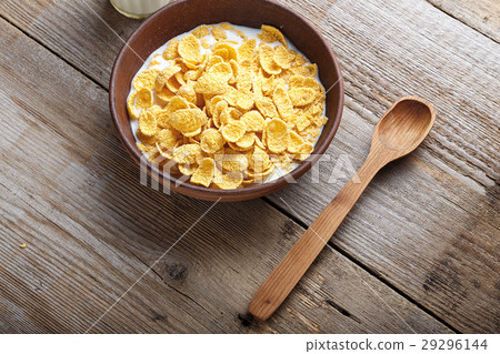 圖庫照片: cornflakes cereal and milk in a clay bowl.