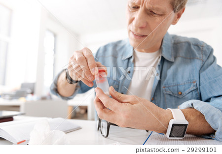 Worried man trying to open package 29299101