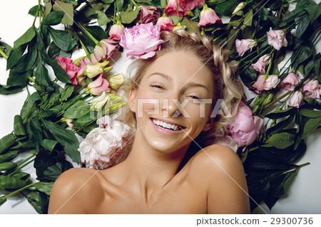 Beautiful girl lying in flowers 29300736