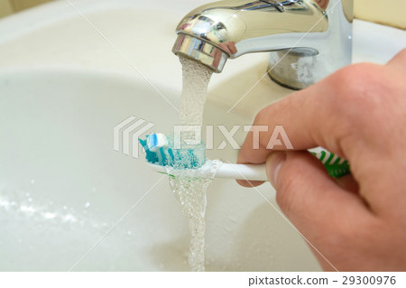 Toothbrush and toothpaste in a hand 29300976