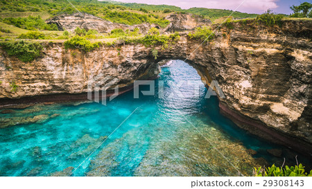 Rock coastline. Stone arch over the sea. Broken Rock coastline. Stone arch over the sea. Broken 29308143