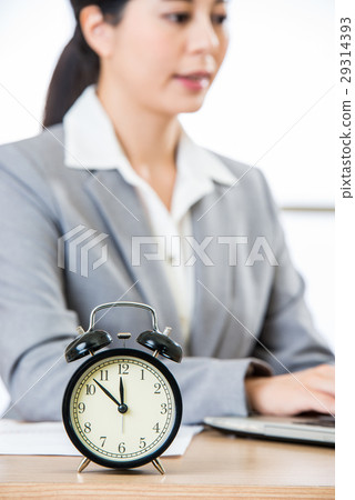 Businesswoman working with clock showing time Businesswoman working with clock showing time 29314393