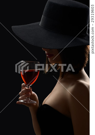 Elegant mysterious woman in a hat holding a glass Elegant mysterious woman in a hat holding a glass 29319603