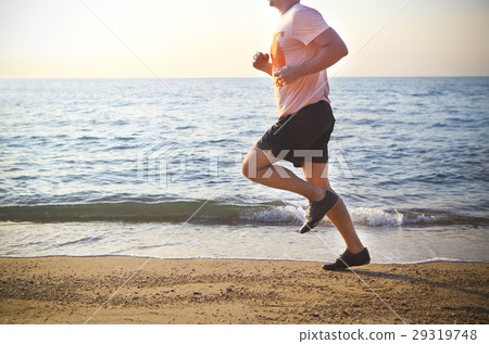 Man running on the beach at sunset 29319748
