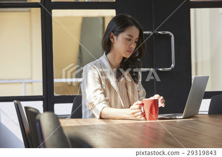 The woman is focusing on the screen seriouly and thinking about something 29319843