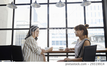 Two young women are talking to each other happlily Two young women are talking to each other happlily 29319914