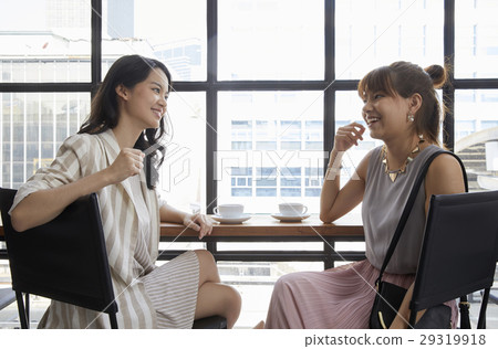 Two bussinesswomen are sitting in the office and discussing for work 29319918