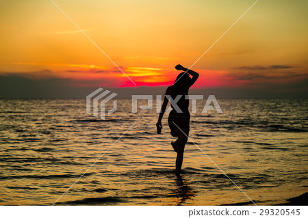 Silhouette of a sensual woman at sunrise on the 29320545