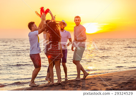 Young People Dancing On Beach at Sunset Young People Dancing On Beach at Sunset 29324529