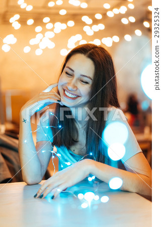 Woman holding glowing christmas garland in hands Woman holding glowing christmas garland in hands 29325324