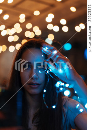 Woman holding glowing christmas garland in hands Woman holding glowing christmas garland in hands 29325331