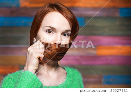 young beautiful red-haired girl covering mouth 29327581
