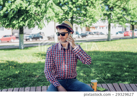 man in  shirt and jeans  glasses, talking on t 29329627