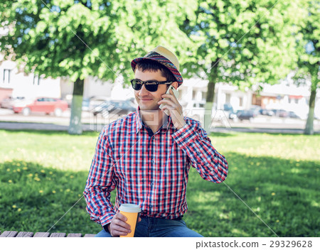 man in  shirt and jeans  glasses, talking on t 29329628