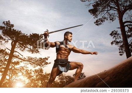 Young muscular warrior with a sword at the Young muscular warrior with a sword at the 29330373
