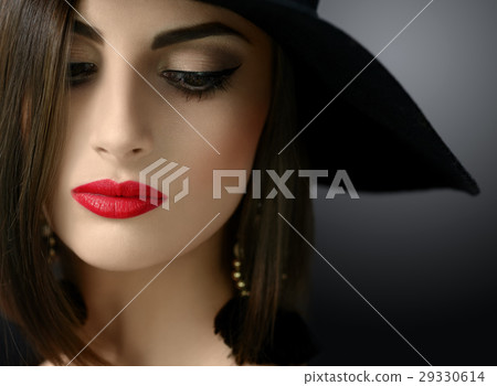 Attractive woman wearing a hat posing on black 29330614