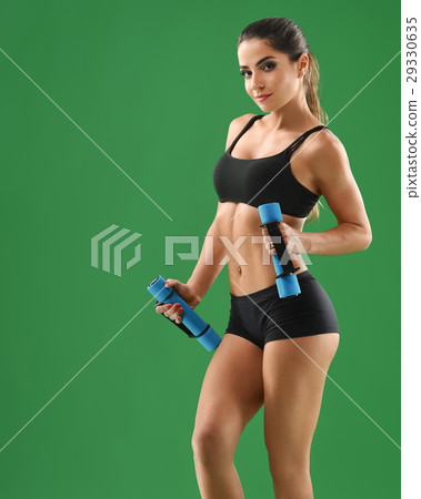 Young attractive woman with dumbbells in her hands Young attractive woman with dumbbells in her hands 29330635