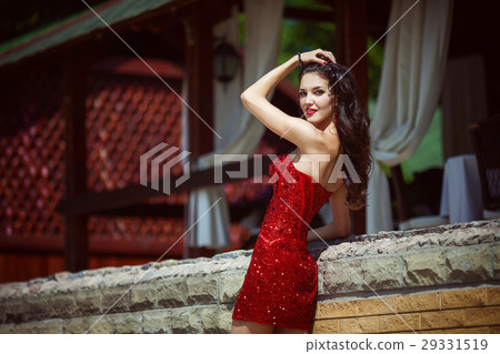 Beautiful young woman with long hair posing in red Beautiful young woman with long hair posing in red 29331519
