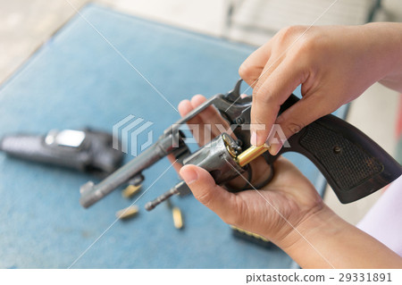people load bullets into revolver gun 29331891
