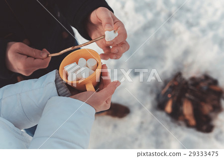 man stringing marshmallow on stick man stringing marshmallow on stick 29333475