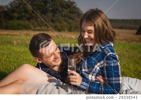 happy couple lying on the grass in the sunny day 29338541