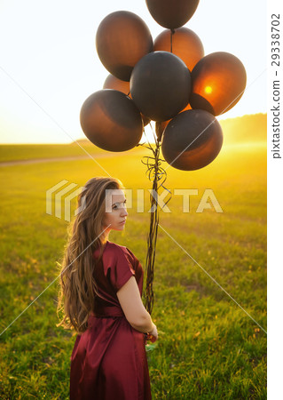beautiful lady in red dress with black balloons at beautiful lady in red dress with black balloons at 29338702
