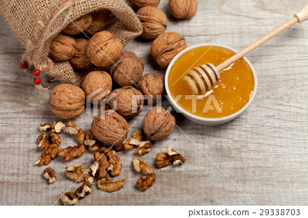 Whole walnuts, kernels and honey on the table 29338703