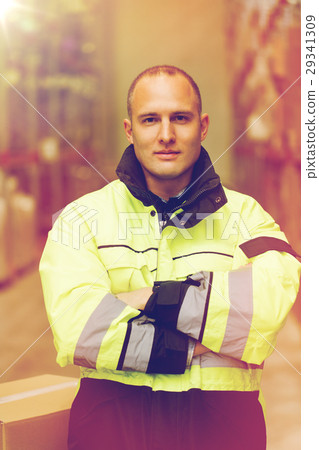 man in coveralls with box at warehouse 29341309