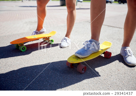 teenage couple riding skateboards on city street teenage couple riding skateboards on city street 29341437