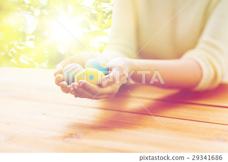 close up of woman hands with colored easter eggs close up of woman hands with colored easter eggs 29341686