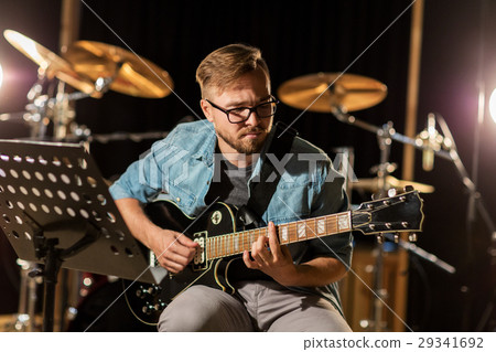 man playing guitar at studio rehearsal 29341692