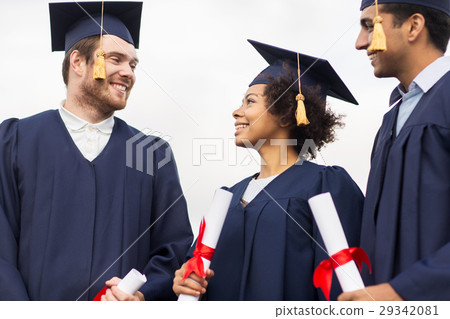 happy students in mortar boards with diplomas 29342081