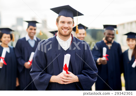 happy students in mortar boards with diplomas 29342301