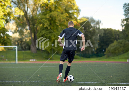 soccer player playing with ball on football field 29343287